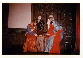 A group of people in clothing playing chess

Description automatically generated